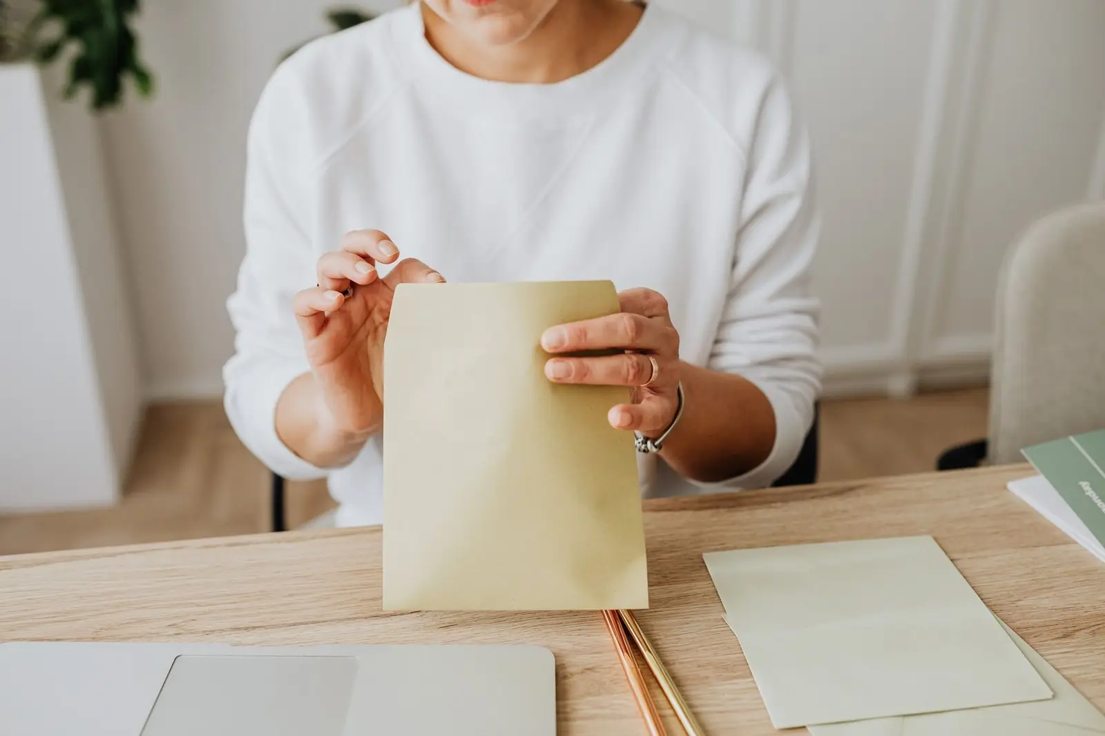 A woman at a desk placing documents into an envelope