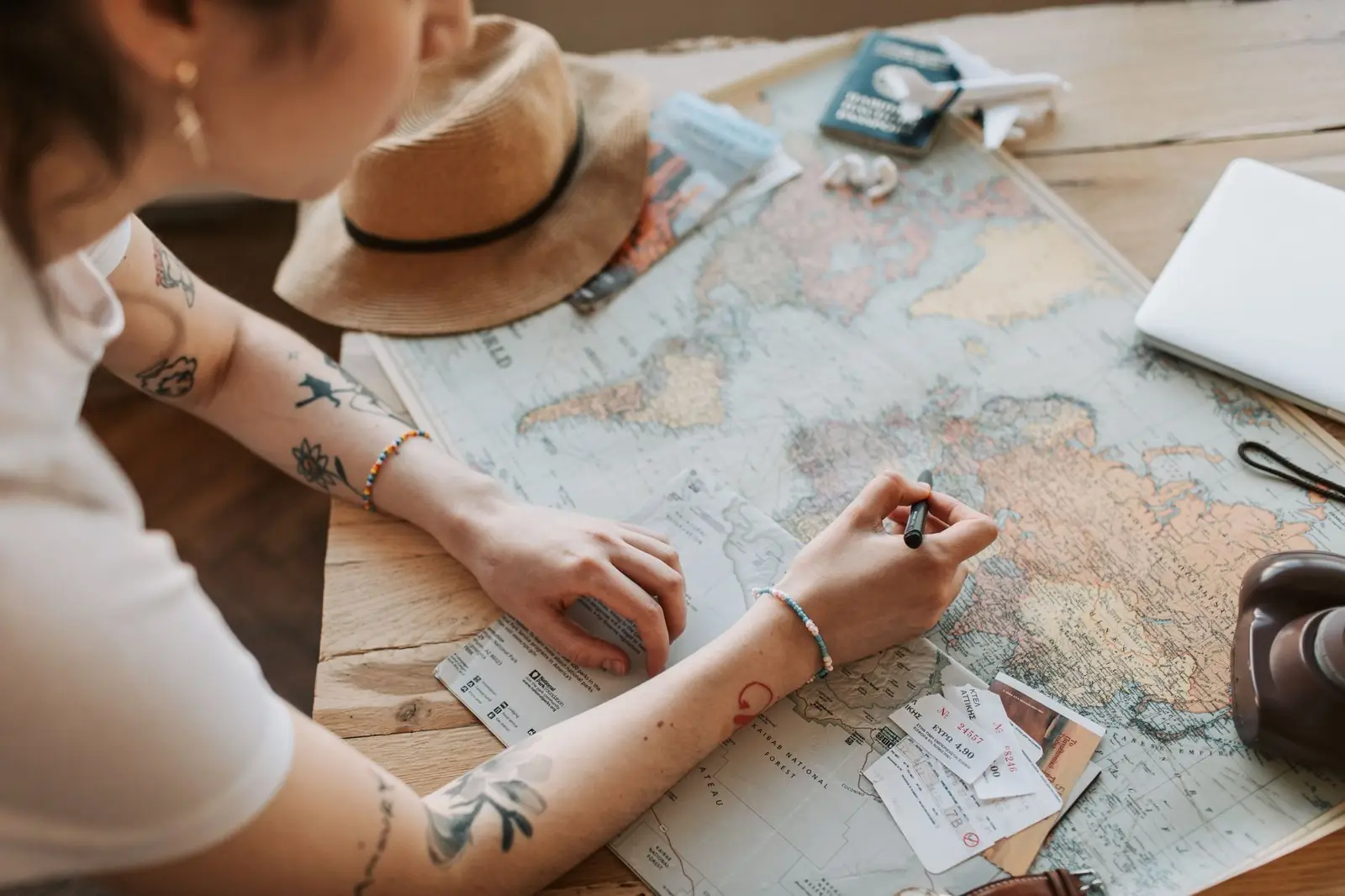 Woman planning a move abroad over a world map with travel papers