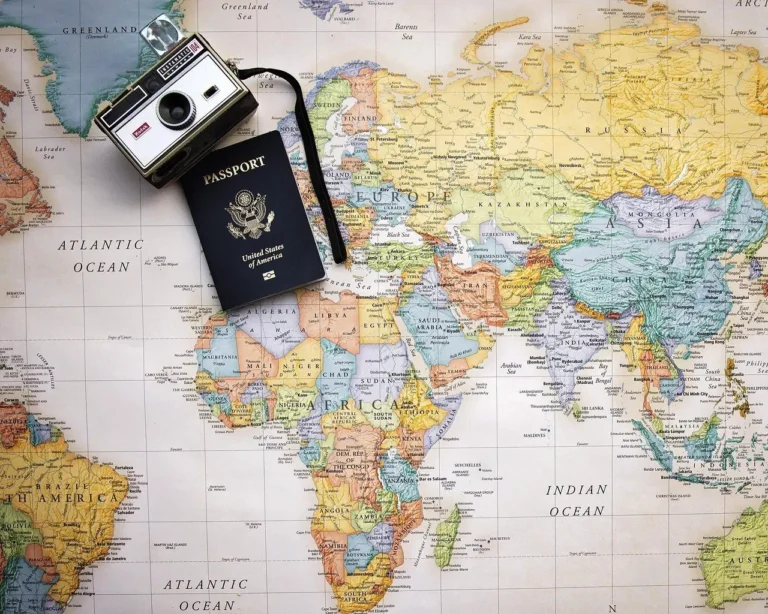 Passport and a camera resting on a world map