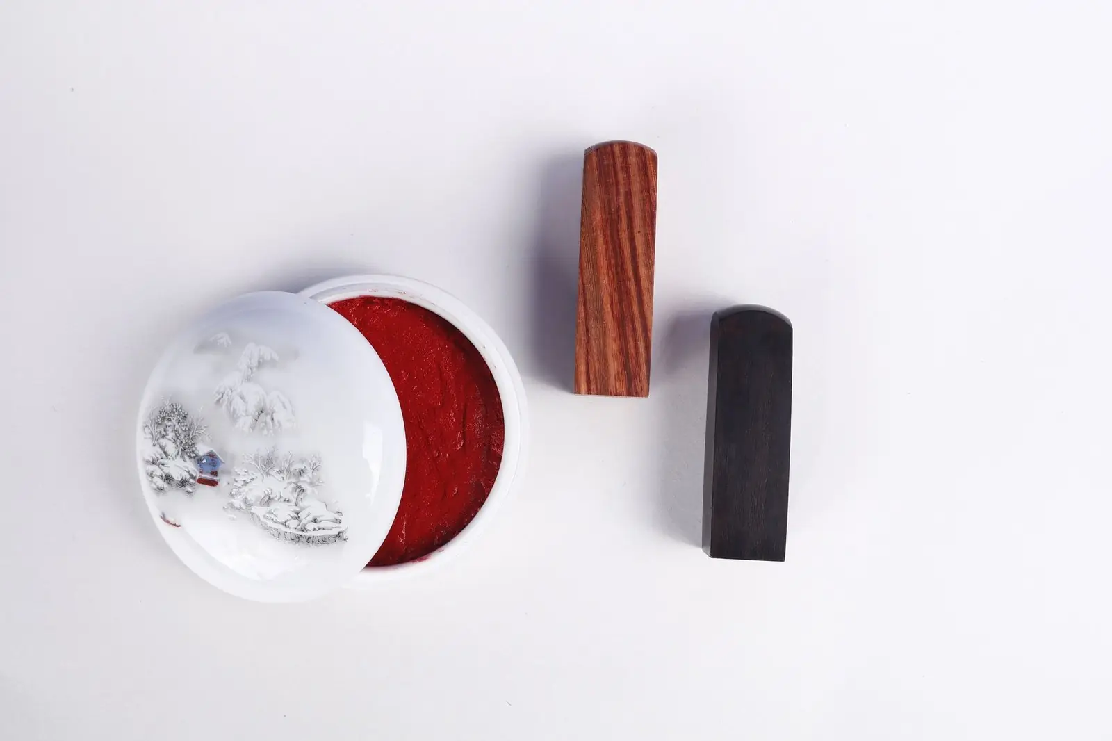 Two ink stamps and an open pot of red ink paste